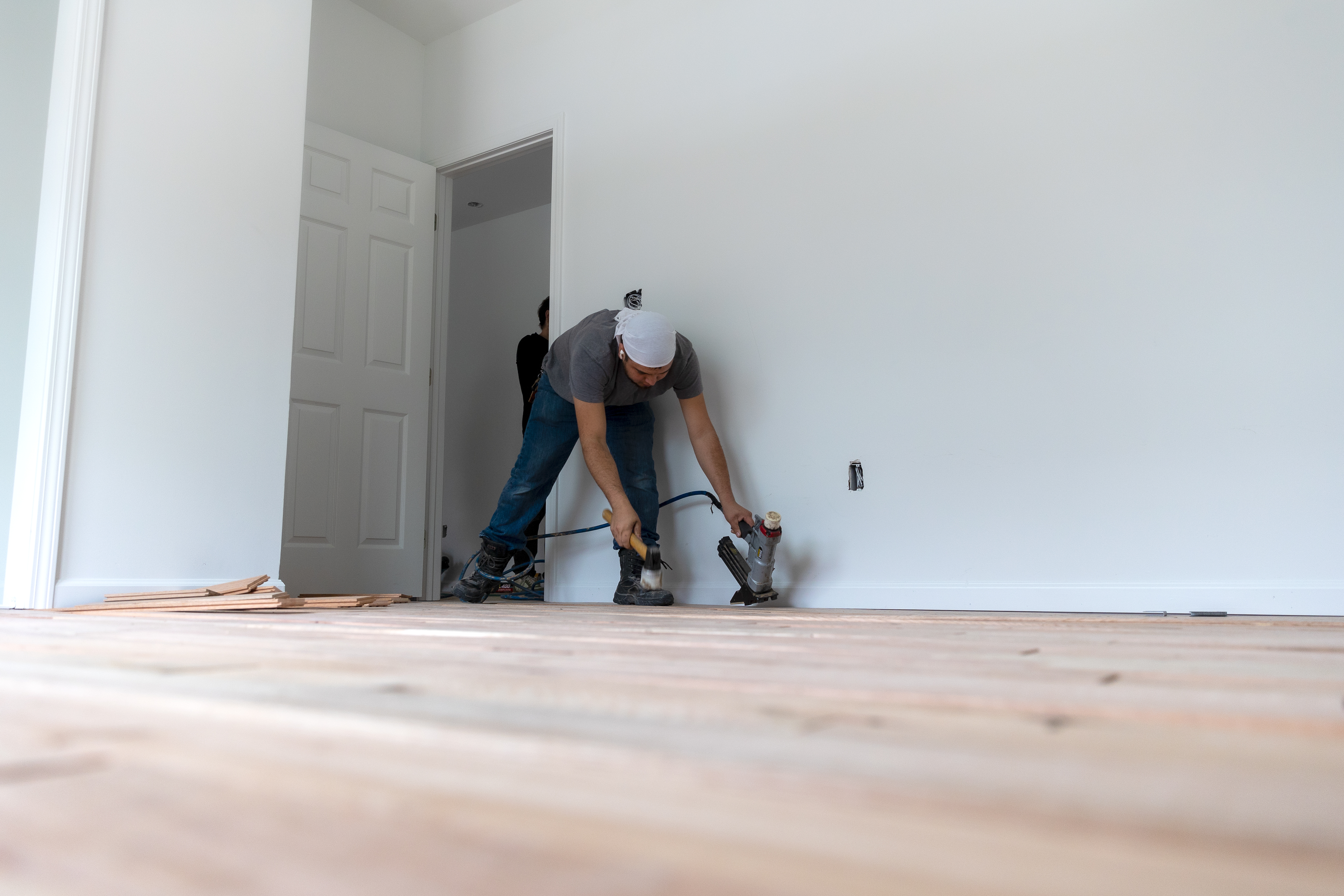 Hispanic male installing wooden flooring